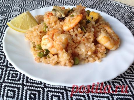 Паэлья с морепродуктами - традиционное испанское блюдо из риса, морепродуктов и овощей для украшения любого застолья