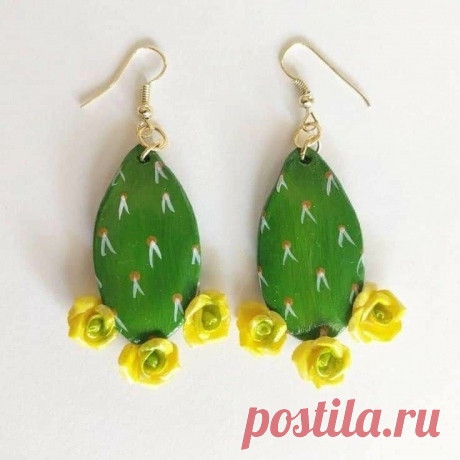 two green and yellow cactus earrings with flowers on the bottom one is dangling from gold plated earwires