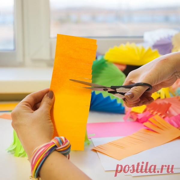 Можно сделать гирлянду — осьминожки. Возьмите лист бумаги. Нарежьте на полоски один край.