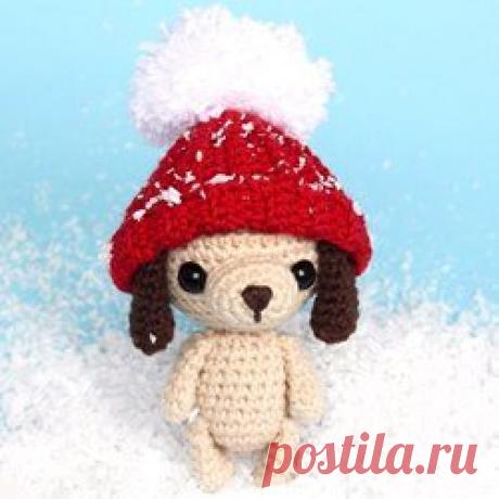 Щенок-брелок крючком: схема амигуруми Маленькая собачка амигуруми в шапочке крючком станет милым сувениром на Новый год, который можно использовать как брелок для украшения рюкзачка или сумочки.