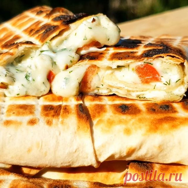 Хрустящий лаваш с начинкой за считанные минуты 😋 На мой взгляд, не существует ничего вкуснее и проще этой закуски! Можно приготовить не только на мангале, но и на сковороде - сочно, мощно и супер вкусно.

Ингредиенты:
лаваш большой – 3 листа;
вареное яйцо – 2 штуки;
сыр сулугуни – 250 грамм;
чеснок – 2 зубчика;
зелень укропа – 1 пучок;
помидор – 1 штука;
майонез (сметана) – 1 столовая ложка;
соль, перец – по вкусу.

Приготовление:
Отварные яйца натираем на крупно...