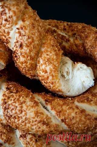 Симиты - турецкие бублики.

Симит - бублик с кунжутом, распространенный в Турции. У него потрясающая хрустящая корочка, и обычно он впечатляющих размеров, хотя сам чаще всего тонок! Самое главное правило - обязательно нужно съесть в день приготовления. Симиты зачастую подают на завтрак с различными закусками, с каймаком и т д. Настоящие симиты делаются в больших каменных печах, но иногда можно отступать от правил:) 
На родине симиты, перед обваливанием в кунжуте, опускают ...