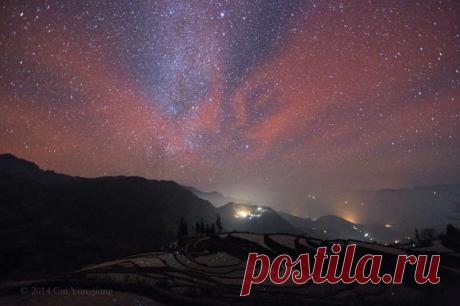 Через довольно долгое время после заката 25 января небо над этим пейзажем с видом на юг заполнило необычное красное свечение. Эта сцена над просторами китайской провинции Юннань была запечатлена с помощью длинной экспозиции цифровой камеры. Это медлительное свечение, едва различимое невооружённым глазом, образовалось из-за хемилюминисценции — излучения света вследствие химического возбуждения вещества.