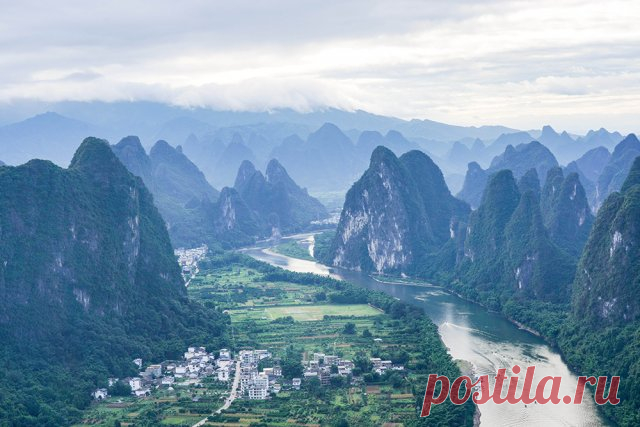 Ландшафт плато Яншо в Китае. С высоты птичьего полета с горы открывается захватывающая дух панорама реки Ли, извивающейся между зеленых холмов.