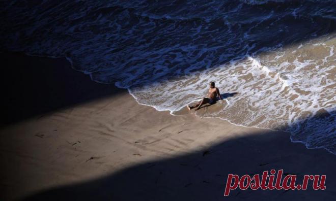 Бразилец загорает в одиночестве между тенями двух зданий — Фото дня, 24 июня 2013