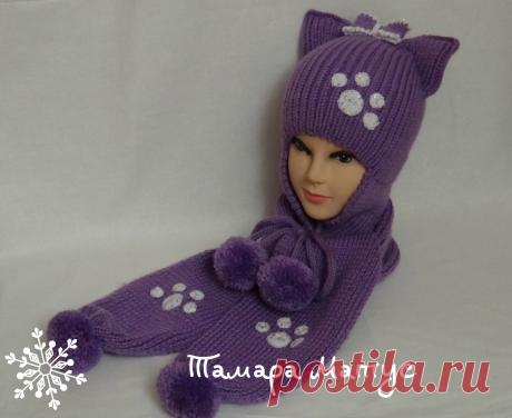 Забавная и игривая шапка-кошка с помпонами для девочки выполнена спицами без швов из полушерстяной пряжи.
Шапочка  очень теплая,толстенькая, плотной вязки рассчитана на межсезонье и зиму. К шапке в комплект связан спицами шарф с помпонами.