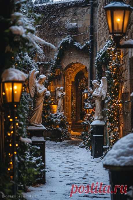 Пин содержит: Snowy garden with angel statues, glowing lanterns, twinkling Christmas lights, and a warmly lit stone archway, ideal for a serene holiday phone wallpaper.