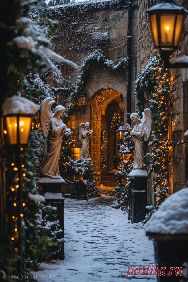 Пин содержит: Snowy garden with angel statues, glowing lanterns, twinkling Christmas lights, and a warmly lit stone archway, ideal for a serene holiday phone wallpaper.