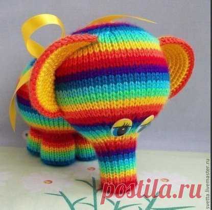 Cлоник вязаный
Работа Светланы Забелиной
Вам понадобится:
— разноцветная пряжа (толщина пряжи должна быть одинаковая),
— набор из 5 носочных спиц № 2,5,
— вязальный крючок № 2,5,
— синтепон или холофайбер в качестве наполнителя,
— глазки от старой игрушки.
Изготовление
Ножки: наберите 21 п. синей нитью и распределите по 7 п. на каждую спицу. Далее вяжите по кругу каждые 2 ряда новым цветом: синим, голубым, красным (можно использовать другие цвета). Далее вяжите розовым цветом следующим образом