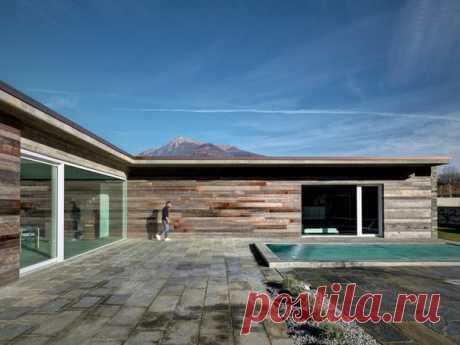 Каменный дом с панорамными окнами Архитектор Рокко Борромини реализовал интересный проект частного дома в городе Сондрио, Италия. Резиденция A.P. House имеет рациональную структуру и функциональное наполнение, используя материалы, вдохновлённые местными традициями. Дом имеет L-образную форму, благодаря которой центральный внутренний двор защищён от ветров и реализована желанная интеграция с окружающим горным ландшафтом. Традиционные каменные стены сочетаются с современными панорамными окнами,…