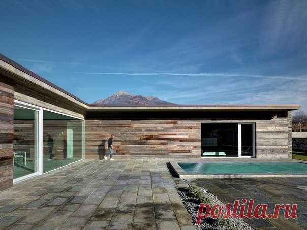 Каменный дом с панорамными окнами Архитектор Рокко Борромини реализовал интересный проект частного дома в городе Сондрио, Италия. Резиденция A.P. House имеет рациональную структуру и функциональное наполнение, используя материалы, вдохновлённые местными традициями. Дом имеет L-образную форму, благодаря которой центральный внутренний двор защищён от ветров и реализована желанная интеграция с окружающим горным ландшафтом. Традиционные каменные стены сочетаются с современными панорамными окнами,…
