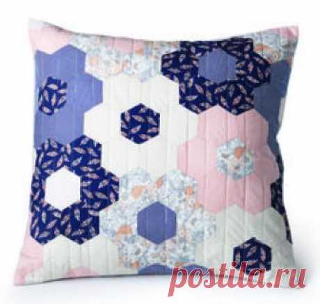 This 20" quilted pillow features hexagon flowers in navy, peach and cream colored patterns. Video tutorial included! #Englishpaperpiecing #MarianneFons #smallproject