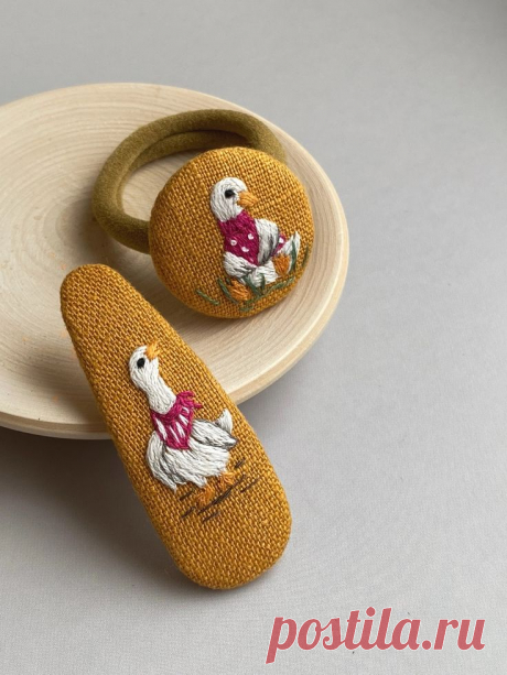 two wooden shoes are sitting on a plate next to another pair of slippers that have been embroidered onto them