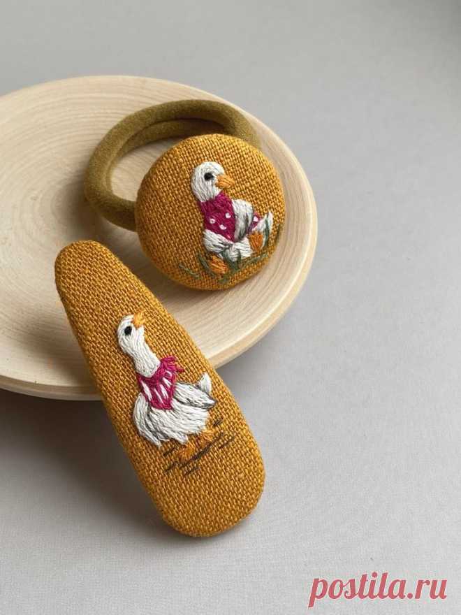 two wooden shoes are sitting on a plate next to another pair of slippers that have been embroidered onto them