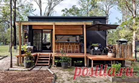 Маленький дом 28 м²: терраса из поддонов, спальни на антресоли, огород и курятник во дворе Еще два года назад герои нашей истории жили в большом коттедже с четырьмя спальнями, просторной гостиной и двумя ванными комнатами. Но устав оплачивать дорогие счета за коммуналку и мечтая о финансовой свободе, они решили переехать в компактный дом площадью 28 м²