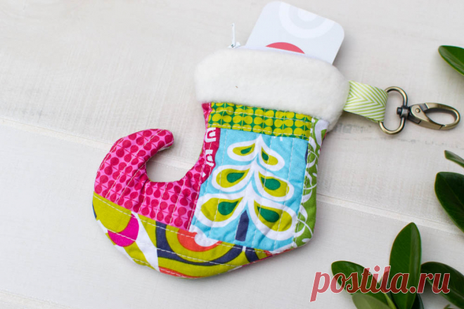 Christmas Stocking Zipper Pouch Tutorial - Perfect for a Gift Card! Here's a quilt-as-you-go project to use up all those cute holiday scraps. This little Christmas stocking zipper pouch is just the right size for a handful of treats or a surprise gift card.