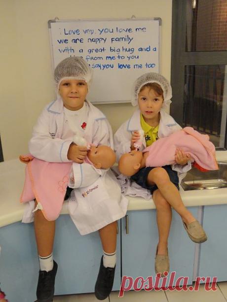 Детская страна Киндмания. Там детишки могут попробовать себя в 80 профессиях, заработав при этом кинд-деньги  и потратить эти деньги на развлечения. На этом фото внук Павлик с другом  только что искупали малышей, надели на них памперсы, запеленали (как смогли) и сейчас кормят.