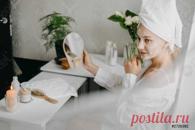 молодая женщина в белом халате, охлаждающая в спальне и делающая когтистую маску для лица возле зеркала девушка, делающая косметические процедуры и расслабляющая дома утренний уход за кожей рутина красоты, уход за собой... - стоковое фото | Crushpixel