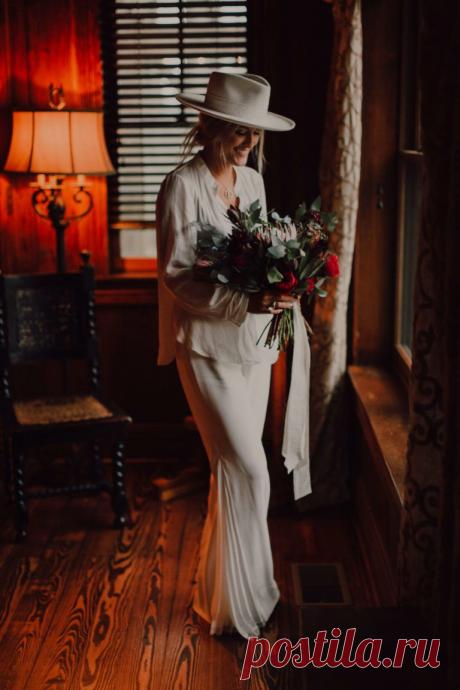 Bride in white bellbottoms and white blazer with white hat holding bouquet with king protea. Nashville wedding elopement | Adventurous Wedding in Nashville #nashvillewedding #adventurouselopement #nashvilleelopement