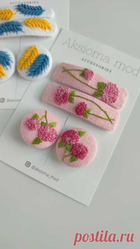 three brooches with flowers on them sitting on top of a card next to each other