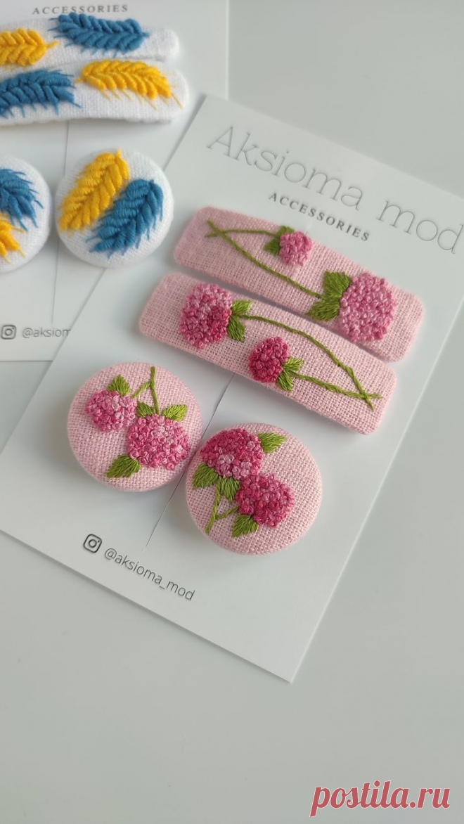 three brooches with flowers on them sitting on top of a card next to each other