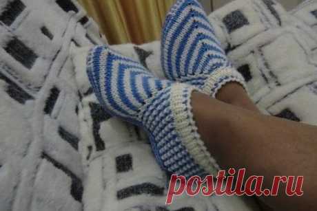 Следки спицами
Набрать 59 петель и вязать полой резинкой,высота резинки по желанию.Затем находим среднюю петлю это 30 петля и в каждом лицевом ряду вяжем из одной петли три(лиц,накид,лиц).Боковую сторону тапочка я вязала рисунком- . :1-й ряд: (лиц. сторона) Нитью А, 1 лиц. п. * 1 снятая изн. п., 1 лиц. п., повт. от * до конца ряда. 2-й ряд: 1 лиц. п., * нить перед изделием, 1 снятая изн. п., нить за изделием, 1 лиц. п., повт. от* до конца ряда. 3-й ряд: Нитью Б, 2 лиц. п., * 1 снятая изн. п., 1