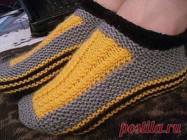 Кто еще не навязался тапочек за эту зиму? Описание для вас  
Набрать на спицы 51 петлю тёмной нитью, провязать 8 рядов платочной 
вязкой. Затем разделить все петли на три части: 17+17+17, и вязатьтолько среднюю часть чулочной вязкой. Боковые петли временно снимаем набольшие булавки. Провязав 10-12 см, у нас получится прямоугольник. Петлине закрываем. По бокам прямоугольника набираем дополнительные петли(примерно 23-25) нитью светлого цвета. Вывязываем 