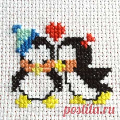 the cross stitch pattern shows two penguins kissing each other