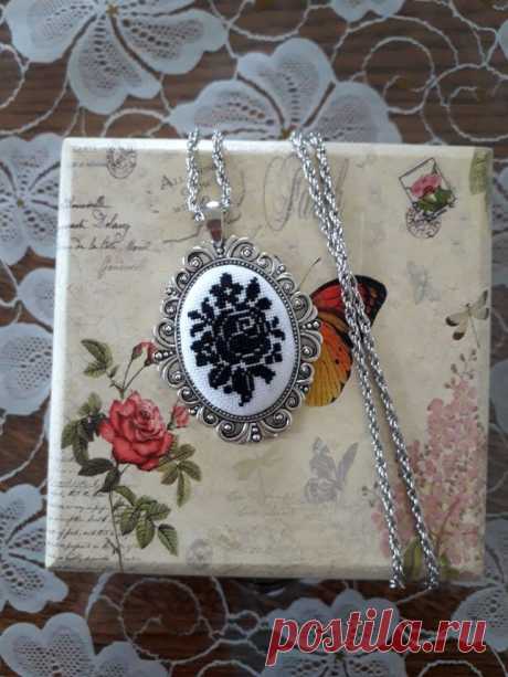 the necklace is decorated with an image of a woman's face and butterfly on it