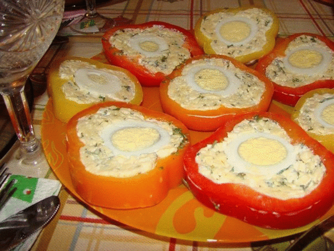 Перец с сырной начинкой и яйцом 
Ингредиенты: 
3 болгарских перца 
300гр. твердого сыра 
Майонез 
3 вареных яйца 
3 зубчика чеснока 
Приготовление: 
Натираем сыр на мелкой терке и добавляем к нему выдавленный чеснок, немного майонеза и перемешиваем. Вымываем перцы, срезаем верхнюю часть перца (чтобы было удобно фаршировать), удаляем из них семена. 
Фаршируем перцы сырной массой, оставив место в середине, в которое мы вставляем яйцо. Плотно заполняем оставшееся место сырной массой. Ставим пе