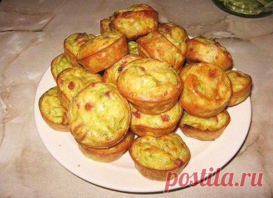 Кабачок 300-350 г очистить от шкурки (если надо), натереть на крупной терке, посолить-перемешать и оставить в дуршлаге, чтобы стекла жидкость, хорошо отжать. Смешать 2/3 стакана муки, 2 яйца, 1,5 ч.л. разрыхлителя, 1-1,5 ч.л. сахара, добавить кабачок, перемешать. В тесто добавить 70-100 г мелко порезанной копченой колбаски. 
Подготовить формочки, уложить тесто. Можно выпекать в силиконовой форме для кексов. Выпекать при 210-215°С 15-20 минут, до подрумянивания.