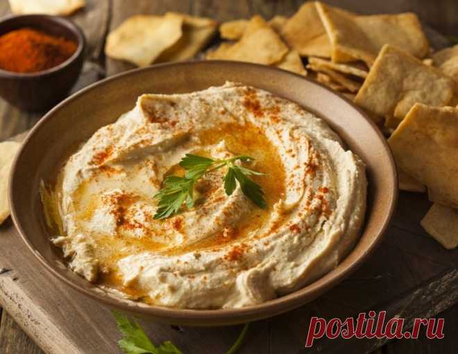 Хумус – 166 Ккал
Если вы никогда не пробовали хумус – срочно это исправьте. Это не слишком калорийный, но очень вкусный и полезный вариант закуски, который может стать альтернативой салату или даже полностью заменить ужин.
Для хумуса возьмите:
сухой нут 300 грамм;
100 грамм кунжута;
половину ч. л. зиры;
лимонный сок – 5 столовых ложек;
3 зубка чеснока;
оливковое масло;
соль.
Готовьте закуску так:
Нут промойте и замочите в воде на 12 часов. Слейте воду, залейте свежей и вар...