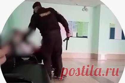 Охранник российской гимназии ударил ученика дубинкой и попал на видео. В Красноярске охранник гимназии ударил одного из учеников дубинкой, инцидент попал на видео. На кадрах мужчина с бородой и в специальной одежде с надписью «Охрана» просит молодого человека встать со скамейки. Юноша не успевает среагировать, и мужчина с размаха бьет его дубинкой по плечу.