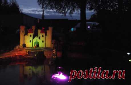 В качестве подсветки можно использовать светильники  рассеянного света на солнечных батареях, которые нужно поместить внутрь замка. Тогда через сквозные окна и открытые ворота замка, расположенные на второй стене, ночью будет струиться слабый свет, оживляя замок и придавая ему таинственность. А солнечные светильники направленного света, встроенные в «камни» и установленные снаружи, будут  со всех сторон подсвечивать стены. Для оживления подсветки можно использовать меняющий цвет светильник,