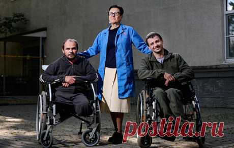 &quot;Мама научила меня доставать ее с того света&quot;. &quot;Теплый прием&quot; для тех, кто выбрал жить. Подмосковье, промзона, небольшой двор. Во дворе разгружают грузовик — в нем банки с солеными огурцами. Рядом — люди в инвалидных колясках. Тут же бегают трехцветная кошка и черный кот. У них на скамейке есть домики — большие коробки с пледами. А у людей, которые здесь находятся, своих домов нет. Зато есть &quot;Теплый прием&quot; — место, где помогут и согреют