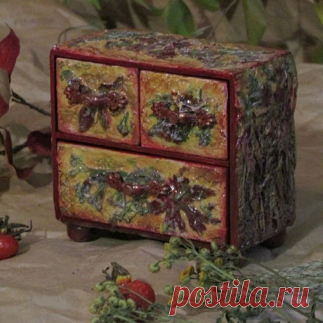 Шкатулка по Мотивам Осени мастера из Петербурга Юли Фомкиной-Еремеевой напоминает осенний лес. Фасад, верх и боковины комодика украшены высушенными растениями. По бокам и дну шкатулки имитация коры дерева выполнена из полимерной глины.