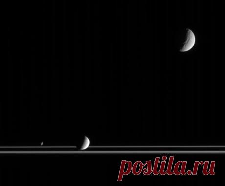 Снимок Кассини в котором, наряду с кольцами, видны спутники Сатурна Тетис, в верхнем правом углу, Энцелад ниже центра и Янус в нижнем левом углу / Astro Analytics