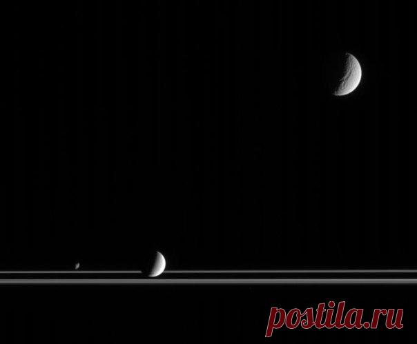 Снимок Кассини в котором, наряду с кольцами, видны спутники Сатурна Тетис, в верхнем правом углу, Энцелад ниже центра и Янус в нижнем левом углу / Astro Analytics