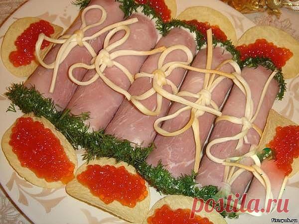 Вкусная и простая закуска

1 плавленый сырок,
250 г нежирной ветчины,
Сыр Косичка,2 яйца,
1 зубчик чеснока,
1 пучок укропа,
Майонез .

Для дополнительно праздничного украшения:
икра  чипсы.

1. Отварить яйца. Измельчить чеснок.
2. Потереть сыр и яйца на крупной терке, смешать с чесноком , заправить майонезом и перемешать.
3. Нарезать ветчину на тонкие пластиночки.
4. На край каждого пласта ветчины выложить начинку и свернуть в свиток.
5. Отделить несколько косичек от сыр