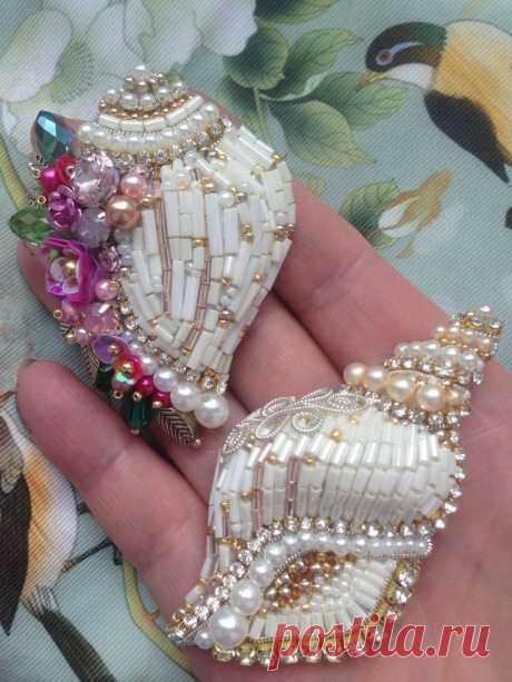 two pieces of jewelry sitting on top of each other in someone's hand,
