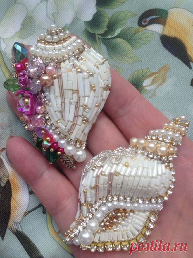 two pieces of jewelry sitting on top of each other in someone's hand,