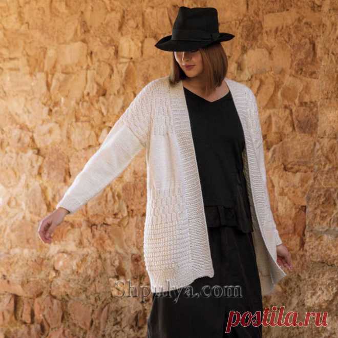 Белый кардиган без застежки связан спицами миксом несложных узоров – лицевая гладь, рельефный, шахматный и жемчужный из мягкой пряжи из шерсти мериноса и акрила.