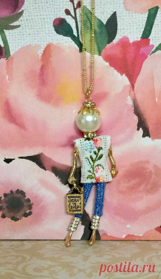 Conoce a Ellies Belle, Addie, una inteligente collar de muñecas de comprador y superestrella con jeans de mezclilla de brillo claro y un top floral con una bolsa Born to Shop en la mano, una…