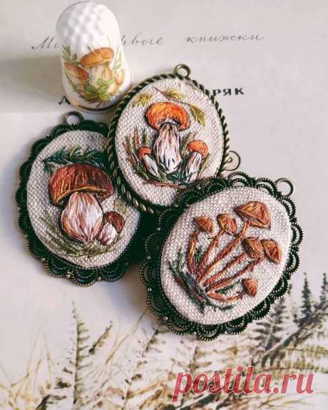 three embroidered coasters sitting on top of a table next to a vase with flowers