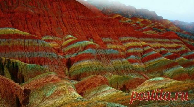 Ландшафт Дэнксия — цветные горы Китая Яркие краски радуют глаз — красноватый песчаник местных гор играет на солнце множеством оттенков. Цветные горы Китая испещрены рисунками причудливой формы, напоминающими морские волны.Сегодня туристы ...