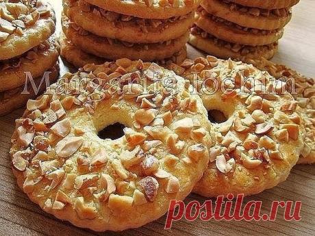 Песочные кольца с орехами.
 
Тесто:
250 г сливоч. масла (холодного) - порезать кусочками
150 г сахара
1 яйцo (среднее)
1 п. ванил. сахара (8 г)
1 ч. л. с горкой разрыхлителя (5 г)
2,5 ст. муки (400 г) - просеять
 
Дополнительно:
1 ст. жареного арахиса (160 г) - порубить не мелко ножом
 
Для смазывания:
1 желток + 2 ст. л. молока - перемешать вилочкой
 
В чашку выкладываем масло, сахар, яйцо, ванил. сахар и разрыхлитель - слегка перемешиваем.
Постепенно подсыпая муку, замеш...
