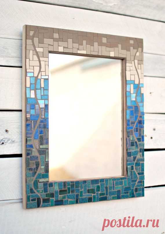 This mosaic mirror features a shift in color and texture, from shiny glass in teal and royal blue at the bottom, to flat unglazed porcelain in