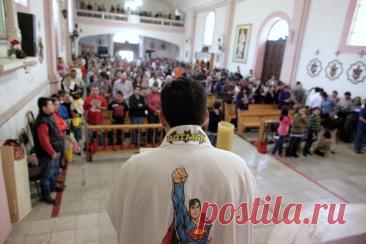 Католический священник Умберто Альварес проводит службу для детей.