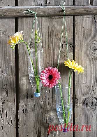 Не хватает зелени на участке?
Попробуйте украсить стены дома или деревянный забор подвесными вазами из пластиковых бутылок.