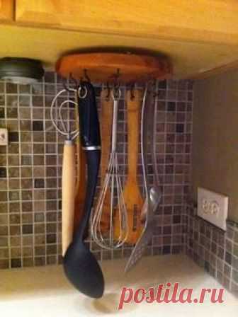 Attach a lazy Susan upside down under a cabinet and add screw hooks to hold kitche